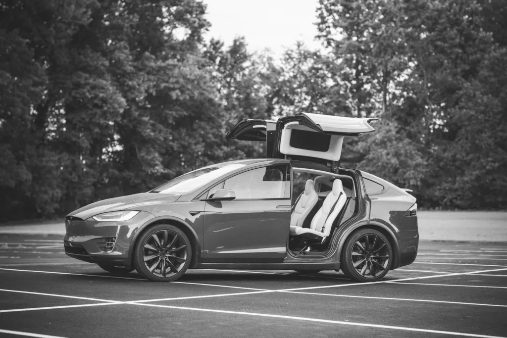 Grayscale Photo of Sports Car on Road