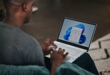 man in gray long sleeve shirt using Windows 11 computer